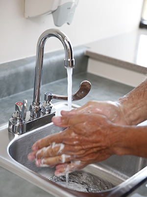 Primer plano de un hombre lavándose las manos en el lavabo.